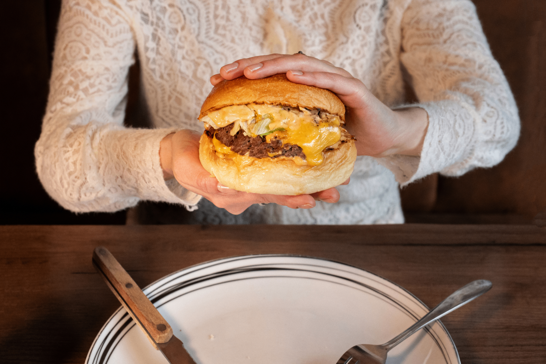Burger signature BOON tenu à deux mains